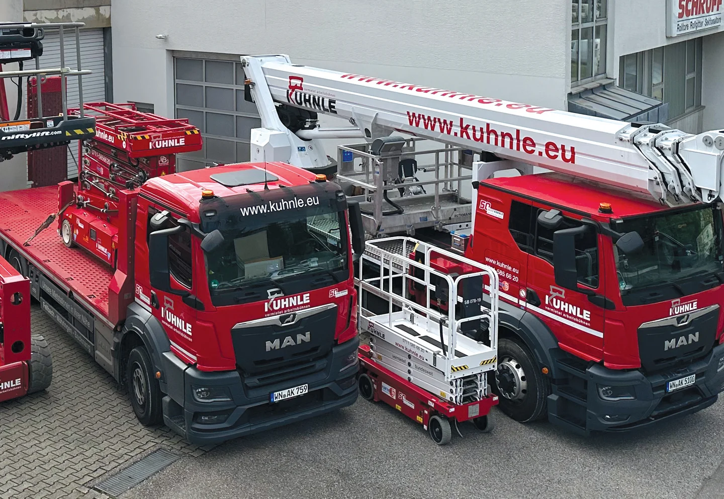 Zwei geparkte rote Arbeitsbühnen.