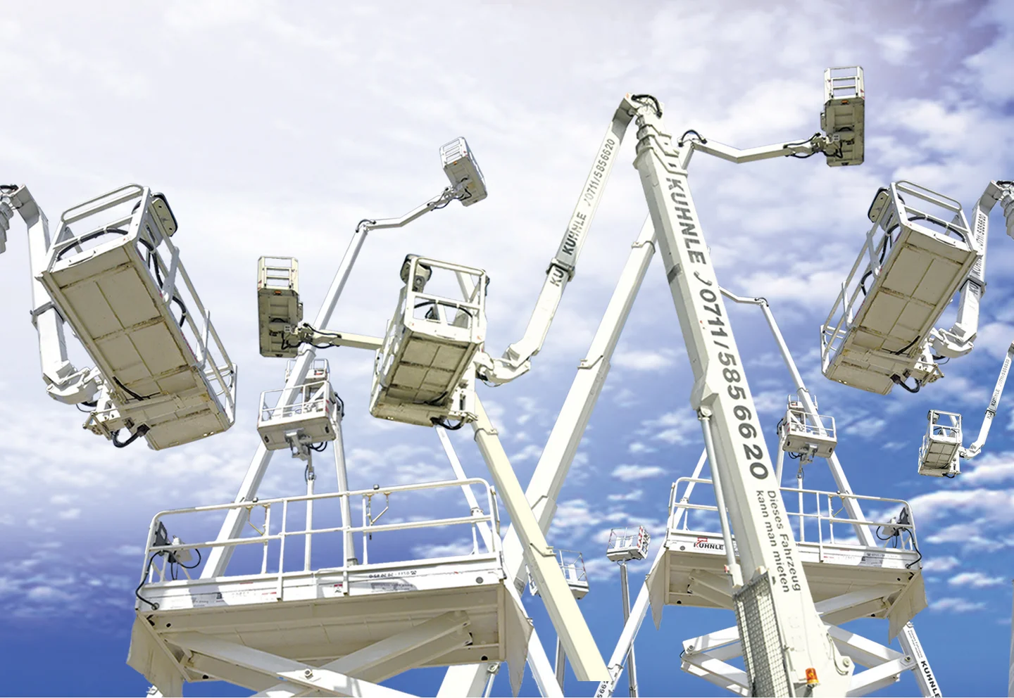 Gruppe von Arbeitsbühnen in ausgefahrenem Zustand vor wolkigem blauen Himmel.