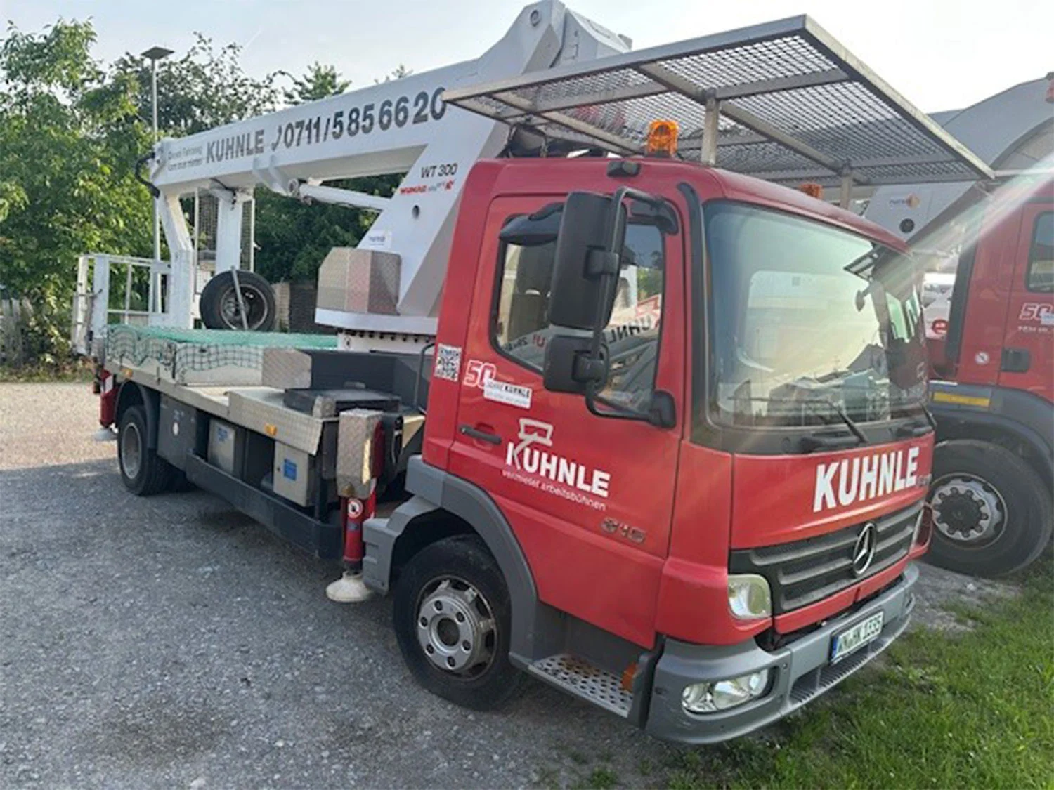 Rote Arbeitsbühne draußen geparkt.