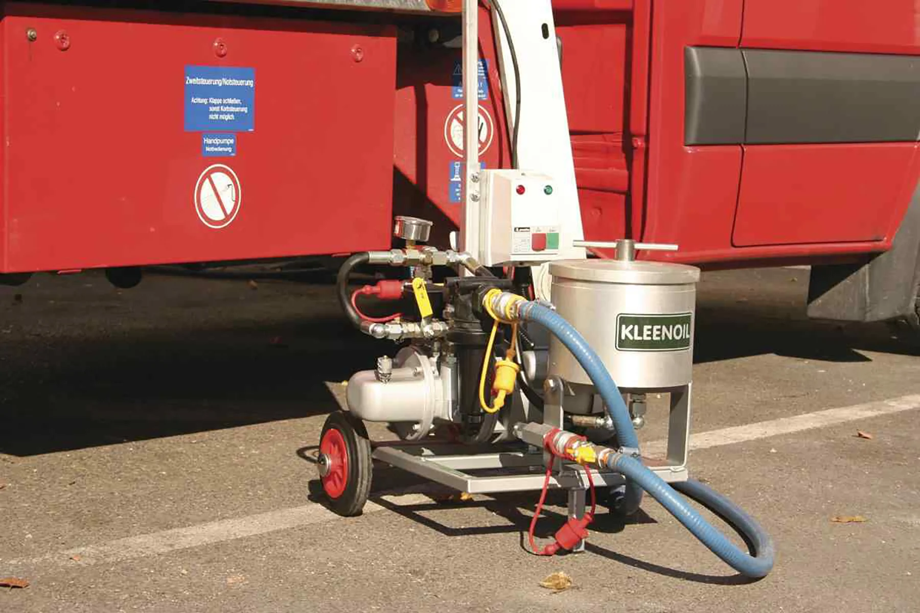Kuhnle Gerät vor rotem Fahrzeug.