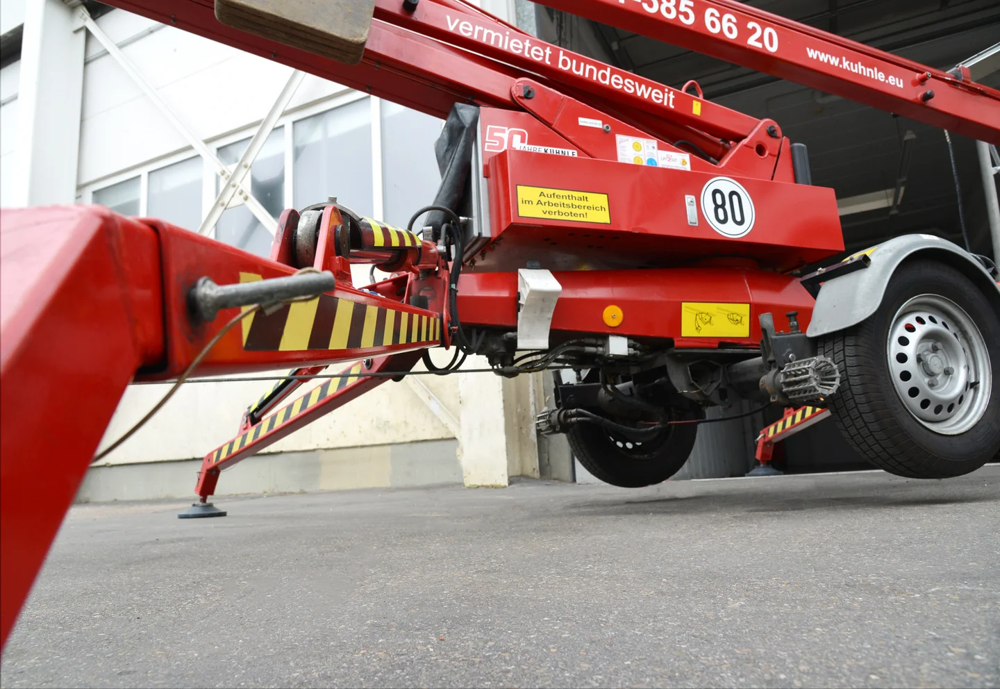 Rote Arbeitsbühne von unten fotografiert, Reifen und Beginn der Bühne sichtbar.